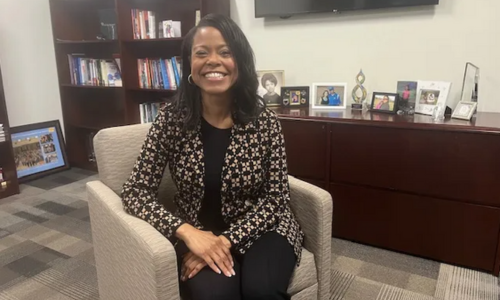  Superintendent Dr. Crystal Hill sits and smiles from a chair in her office.